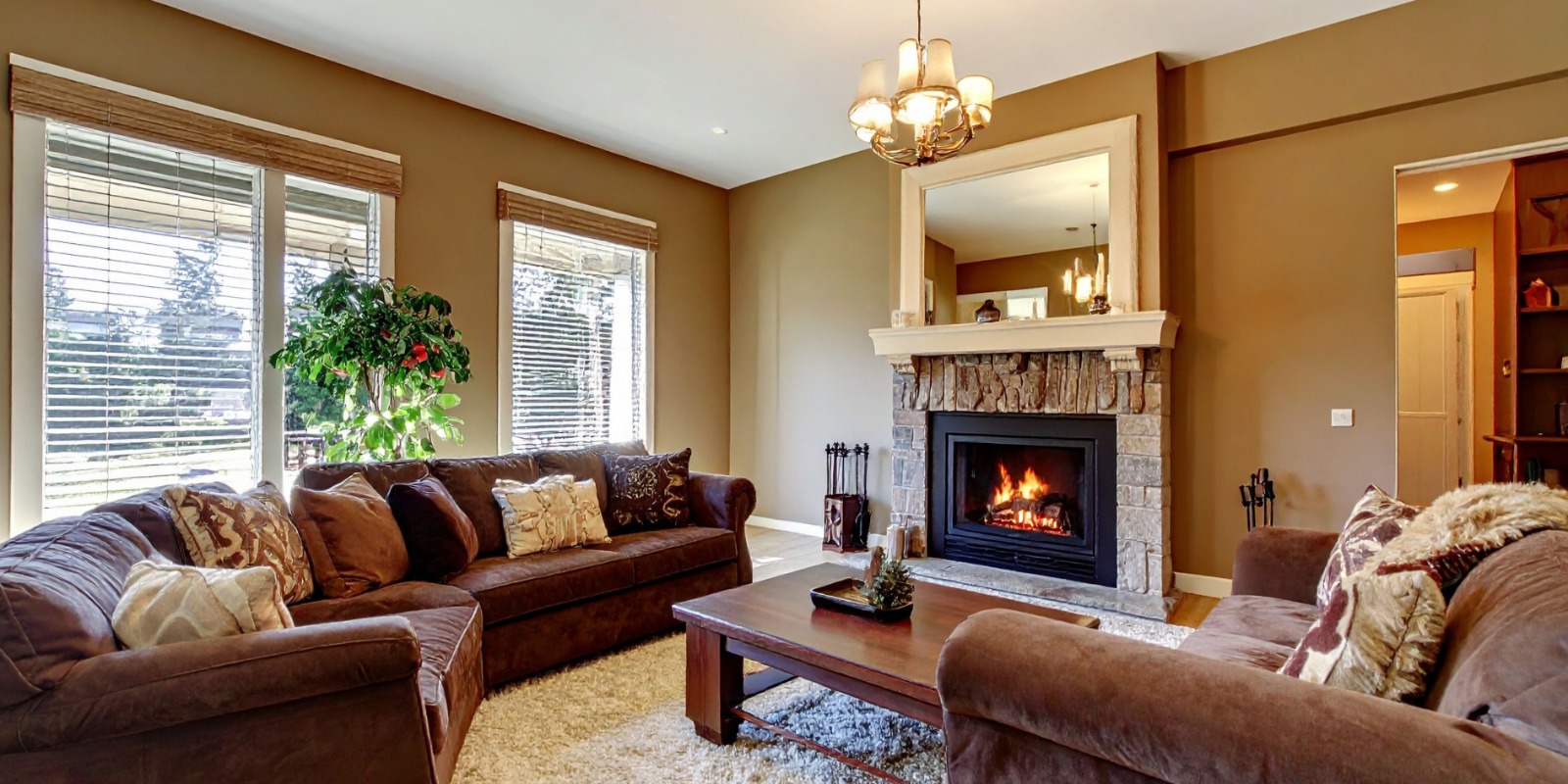 Bright open-plan living room with white linen sofas, sheer curtains, and natural light flooding in through tall windows.